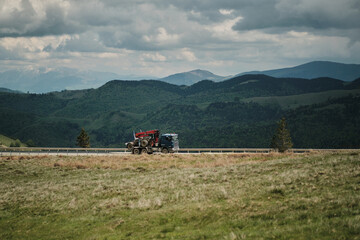A lone logging truck travels along a scenic mountain highway.  Rolling hills and a cloudy sky...