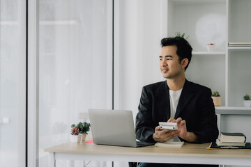 Fototapeta premium Thoughtful Businessman at Desk with Laptop