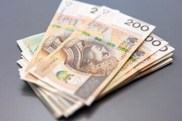 Banknoty, złotówki, pieniądze leżące na szarym tle