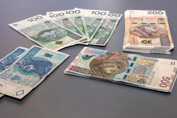 Banknoty, złotówki, pieniądze leżące na szarym tle