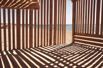 Fototapeta premium Sunlight Streaming Through Wooden Beach Structure