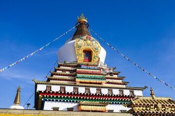 Colorful Dudul Chorten at Kirti Monastery in Ngawa, a prominent Tibetan Buddhist stupa in Amdo, showcasing traditional Himalayan architecture and prayer flags.


