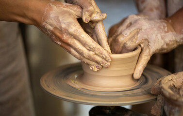 Potter's hands working clay on a potter's wheel 