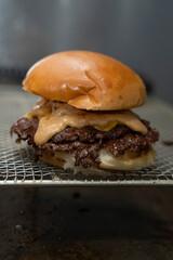 Close-Up of a Juicy Smash Burger with Special Sauce and Melted Cheese on Grill Rack