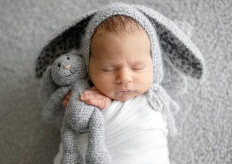 Newborn Baby Sleeping In A Bunny Hat In A Studio Photo