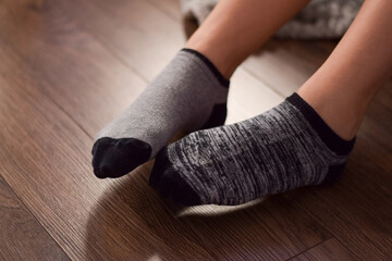 Closeup feet of teeange girl in gray mismatched socks