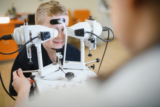 Ophthalmologist performing vision diagnostics on child with modern equipment
