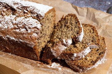 Freshly made banana bread loaf on a wooden board. 