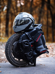 Electric Unicycle and Helmet in Autumn Park © pavelkant