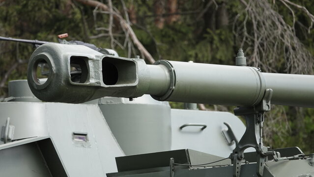 The muzzle of a large-caliber artillery installation with holes for powder gases exit, closeup