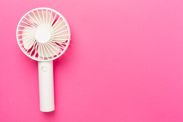 Mini electric fan on color background, top view