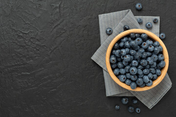 Bowl with fresh bright blueberries on concrete background,top view