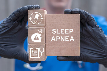 Doctor holding wooden blocks with icons sees inscription: SLEEP APNEA. Sleep Apnea Neurological Disorder Diagnosis Treatment Medical concept.