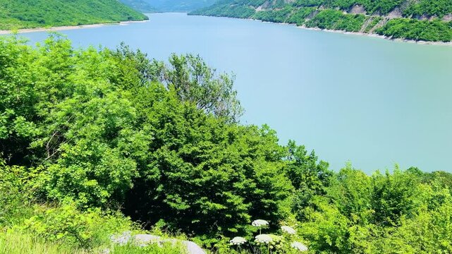 The Zhinvali reservoir, the lake landscape with mountains, the main Caucasian ridge, the Georgian military road. Georgia. An artificial reservoir. Blue sky with white clouds. 4К