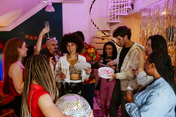 A lively indoor party of diverse young friends enjoying drinks, cake, and laughter in a festively decorated house. The concept of a joyful birthday celebration with friends.