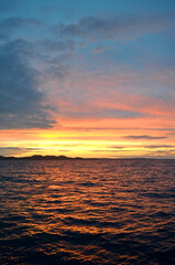 Golden sunset over the Adriatic Sea with distant Dinaric Alps silhouettes in Zadar, Croatia