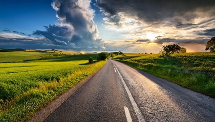 Fototapeta premium scenic road in countryside with dramatic sky and vibrant landscape elements