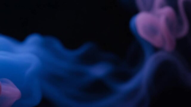 Abstract blue and pink smoke wisps on a black background.