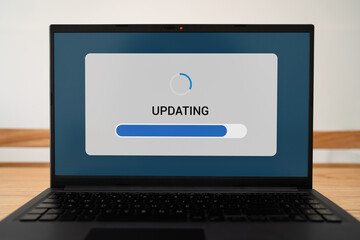 Concept of updating software process. Progress bar on laptop screen.