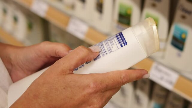 Conscious shopper carefully examines shampoo bottle in store analyzing ingredients and checking quality Shampoo label provides key insights Shampoo choice reflects mindful and informed consumption