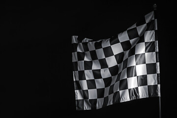 One racing checkered flag on black background, space for text