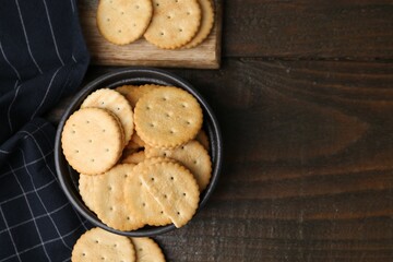 Tasty salty crackers on wooden table, flat lay. Space for text