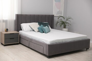 Comfortable bed with new soft mattress and pillows indoors