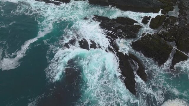 Footage shows powerful ocean waves crashing on the rocky coastline of Lastras de Pechon, demonstrating the natural power of coastal environments.