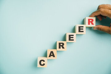 Career planning and growth. A hand places a wooden cube block labeled CAREER on a vibrant blue background, offering copy space for text and emphasizing the significance of business success.