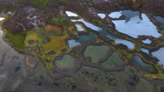 High-resolution 4K drone view of the Kyles Flodda, showing a rare coastal landscape of intertidal pools, sandy islets, and wetland habitats in Scotland&rsquo;s Outer Hebrides.
