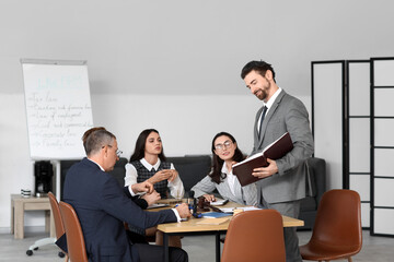Male lawyer working with colleagues at table in office