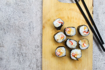 Sushi pieces on wooden board with chopsticks with negative space.Japanese food.