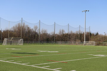 A view of a soccer field and sport activity. Sports field with a large net and a black sky. Competition and playground.