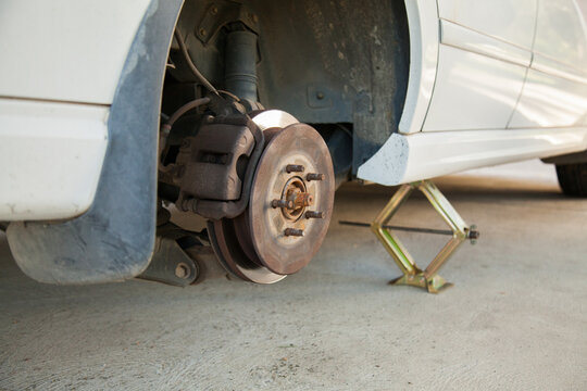 Car resting on jack while changing to spare tyre