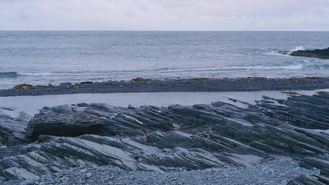 Aerial footage showing flysch formations, layered sedimentary rocks stacked along coastal cliffs at Cape Nemetsky, Vaida Bay