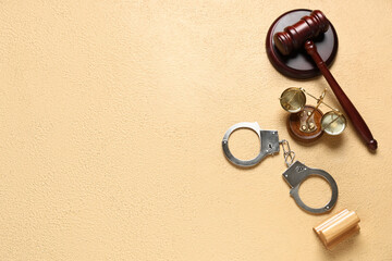 Judge's gavel, scales of justice, handcuffs and stamp on beige background