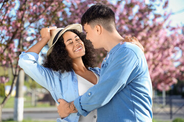 Beautiful young happy couple in park on spring day