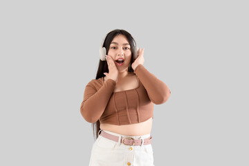 Naklejka premium Surprised young woman in headphones on light background