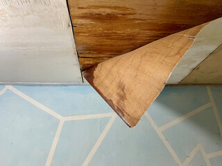 The roof ceiling of the house made of plywood peeled off and rotted due to rainwater. The concept of a damaged house ceiling