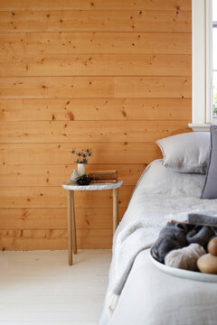 Marble bedside table with timber wall, grey bed linen and wool