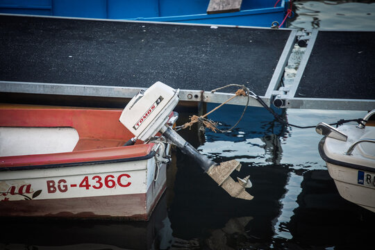 BELGRADE, SERBIA - MARCH 22, 2025: Close-up of a Tomos 4 outboard engine on a motorboat beside a floating dock in belgrade, serbia, representing Yugoslav engineering.