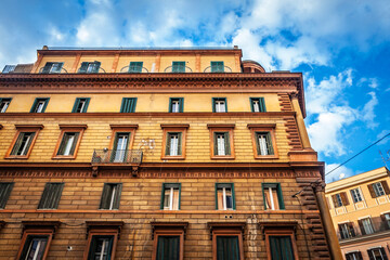 Upward view of a late-19th-century residential palazzo in Rome's historic center, in italy, ochre...