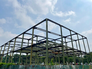 Building frame with a series of iron frames and at the bottom corrugated zinc sheets with a blue sky background