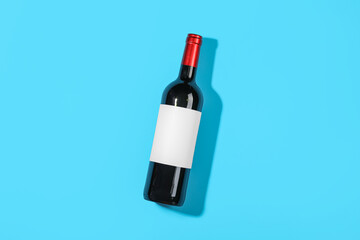 Obraz premium Bottle of wine with blank label on blue background