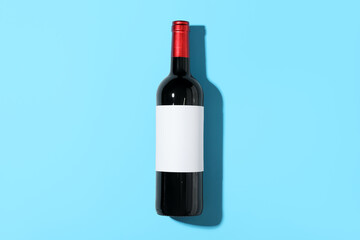 Bottle of wine with blank label on blue background