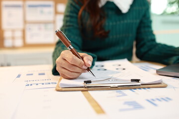 A professional woman wearing a headset works at her desk in a modern office, communicating with a...