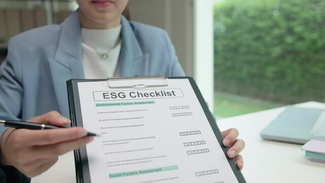 Asian female audit ESG risk check list paper form net zero waste supply chain vendor eco go green carbon credit control. Asia people woman give advice report prepare work review best practice process.