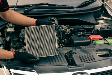 Technician auto mechanic holding car air conditioner filter for check and clean dirty or fix repair...