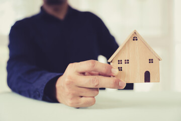 Hand choose house for financial planning or plan of money savings or for home loan management for buy housing residential or family insurance or banking agreement.