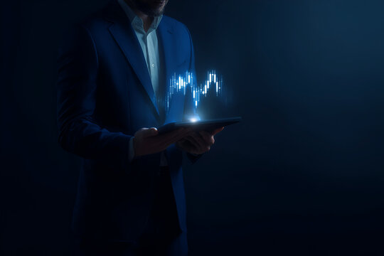 Businessman analyzing holographic financial data on a digital tablet in a dark environment - Powered by Adobe